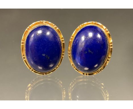 A pair of 18ct gold mounted lapis lazuli oval cabochon earrings, fixed pillar and clips, stamped 750, Sheffield 1991, 7.2g gr