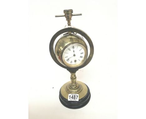 A brass compass clock the case within a brass gimbal with barometer dial and clock dial on a brass column. With key. Hight 33