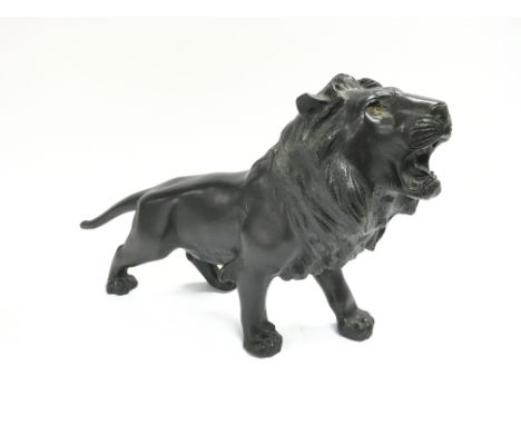 A bronze lion. Approximately 39cm wide by 22cm high. Damage to tail.