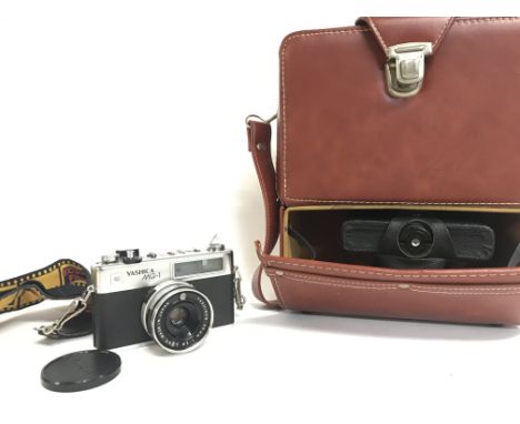 A cased Yashica MG-1 with lens. Postage category C