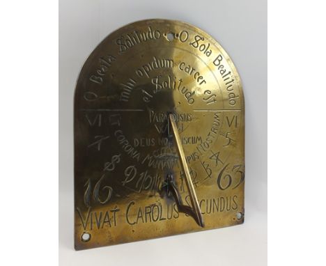 AN EARLY BRASS SUNDIAL, wall mounting arched plate, engraved with text and calibrations, bears the date 1663, and the inscrip