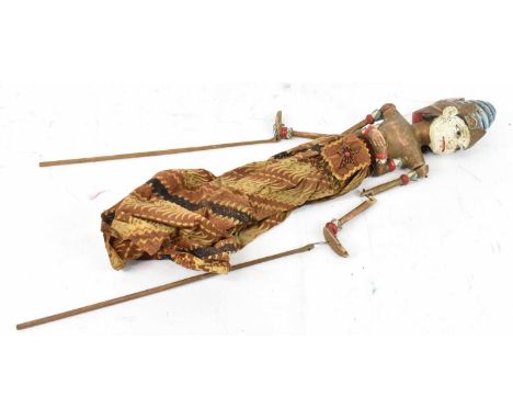 A vintage Indonesian stick puppet with overall painted decoration, length approx 65cm.