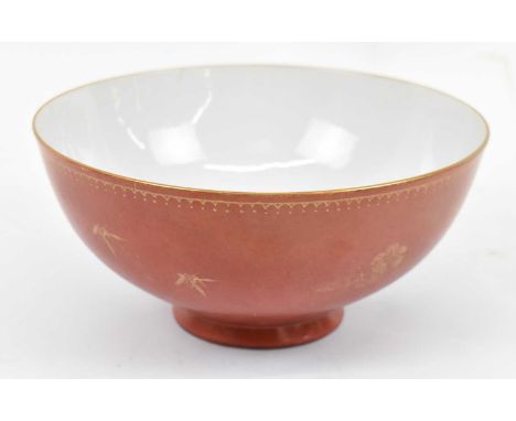 A 19th century Chinese porcelain bowl, the exterior with gilt floral decoration on a terracotta ground, bears Qianlong mark t