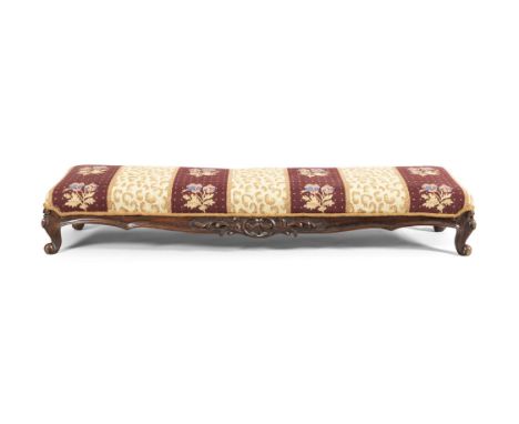 A VICTORIAN CARVED AND STAINED BEECH FRAMED LONG FOOTSTOOL, the padded top covered in tapestry cloth and raised on cabriole l