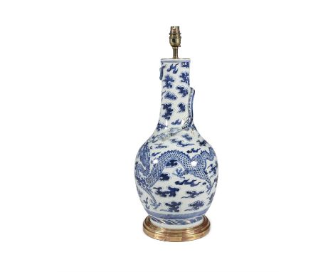 A BLUE AND WHITE ORIENTAL BALUSTER SHAPED VASE,the body wrapped with a four claw dragon amongst clouds, on a gilt base, 48cmC