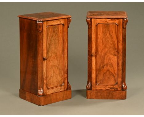 A pair of Victorian walnut bedside cupboards, each with moulded edge and rounded corners and with canted angles with corbels 