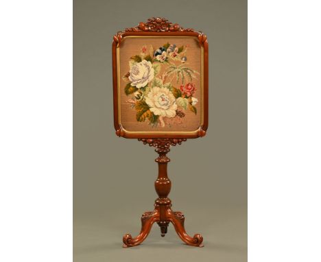 A Victorian mahogany pole screen, with woolwork tapestry panel, with turned support and downswept legs terminating in scroll 