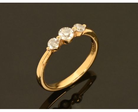 An 18 ct gold three stone diamond ring, total diamond weight +/- .50 carats.  Size O.