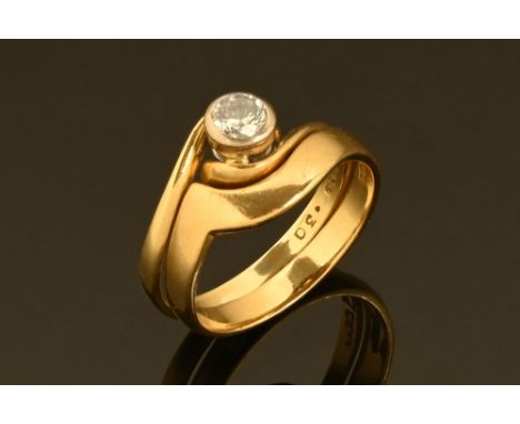 An 18 ct gold solitaire diamond ring, with shaped wedding band retaining hoop.  Band weight 2.2 grams, solitaire weight 1.6 g