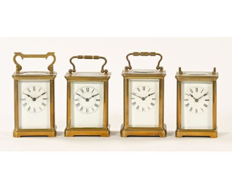 A collection of four brass carriage clocks, each with white enamel face and dial, all +/- 11 cm high.