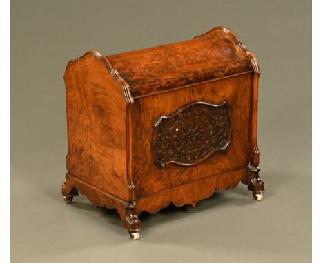 A Victorian walnut enclosed Canterbury, with fretwork panels and of shaped outline raised on short castors.  Height 52.5 cm, 