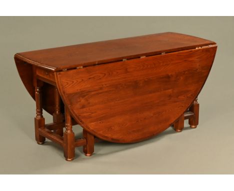 A large oak and crossbanded gate legged dining table, with D shaped flaps and raised on turned legs with low stretchers.  Hei