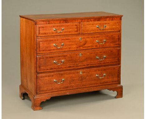 A George III oak and mahogany crossbanded chest of drawers, two short and three long drawers with brass drop handles and bras