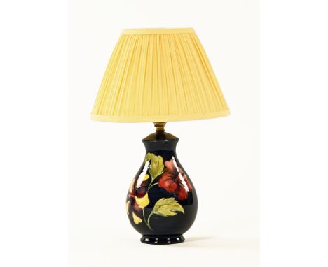 A Moorcroft orchid patterned table lamp, with blue ground and impressed Moorcroft Made In England.  Height excluding light fi