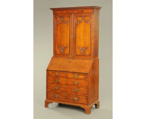 A George III oak and mahogany crossbanded bureau bookcase, with detachable moulded dentil cornice above a pair of panelled do