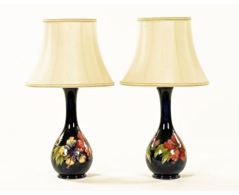 A pair of Moorcroft orchid patterned table lamps, blue ground, each impressed Moorcroft Made In England.  Height excluding li