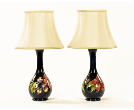 A pair of Moorcroft orchid patterned table lamps, blue ground, each impressed Moorcroft Made In England.  Height excluding li