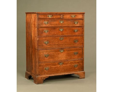 A George III tall oak chest of drawers, two short and five long graduated drawers with brass drop handles with pierced backpl