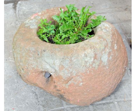 A red sandstone circular trough, with circular aperture to centre.  Height 34 cm, diameter 46 cm.