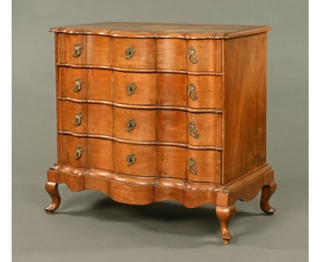 A large Continental oak serpentine fronted chest of drawers, with moulded edge, four long drawers with brass handles and rais