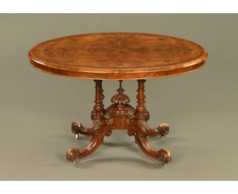 A Victorian walnut and marquetry inlaid tilt top breakfast table, the oval top raised on a base of four turned legs with a ce