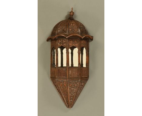 A Middle Eastern carved wall bracket, with pagoda type top and mirrored back.  Height +/- 100 cm, width 50 cm, depth 24 cm.