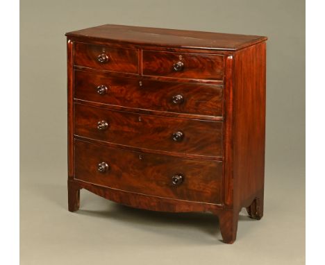 A Victorian mahogany bowfronted chest of drawers, two short and three long with wooden knob handles flanked by applied mouldi
