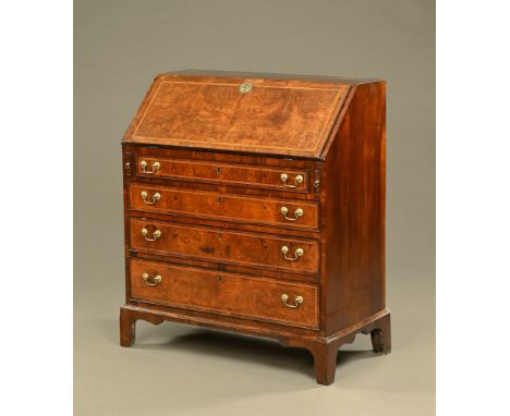 A George III mahogany and walnut bureau, chevron banded, the slope front with tooled leather writing surface and with fitted 