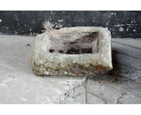 A small sandstone trough, of shaped outline with drain hole to centre.  Height 20 cm, width 52 cm, depth 40 cm.