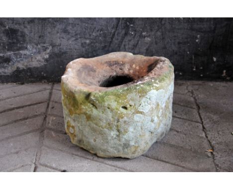 A sandstone trough, cylindrical with centre aperture and hole to both sides.  diameter +/- 49 cm, height 32 cm.