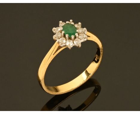 An 18 ct gold emerald and diamond cluster ring.  Size O.