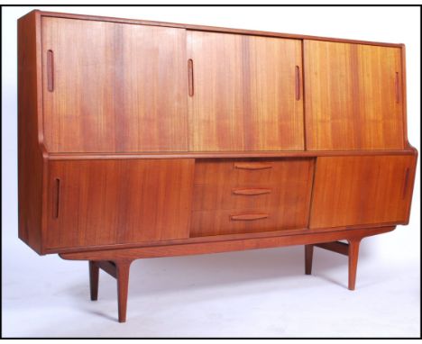 A Danish mid Century retro vintage teak wood highboard&nbsp; / sideboard having an angular sloped and tilted front comprising