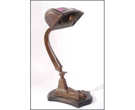 A 1930's Art Deco bronzed brass desk lamp having shaped arm with cylindrical wide pendant shade. All set over a wooden plinth