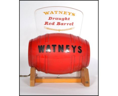 A vintage retro 20th century Watneys Draught Red Barrel" bar top advertising light display. Raised on a wooden plinth base wi