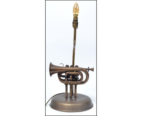 An unusual 20th century table lamp constructed from an upcycled&nbsp; Boosey and Hawkes trumpet raised on a stepped circular 