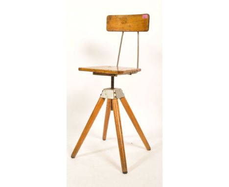 A mid 20th Century vintage industrial lacquered pine revolving stool / chair having a curved backrest and raised on tapering 