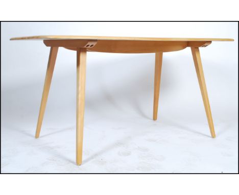 Ercol - An excellent 20th century beech and elm wood refectory plank dining table being raised on shaped supports united by c