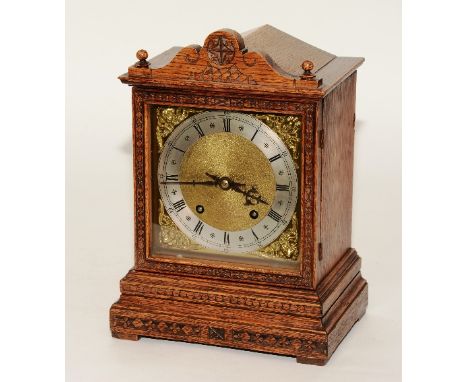 An early 20th century oak cased bracket clock, the silvered dial with Roman numerals, minute track, decorated with a gilt met