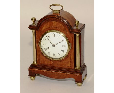 An Edwardian mahogany inlaid and brass mantel clock, with brass carry handle, flanked with a ball finial above enamel dial wi