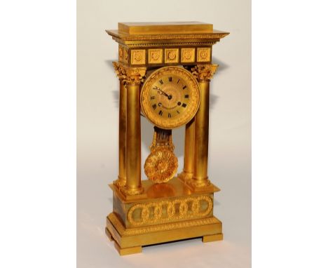 A 19th century French empire ormolu portico mantel clock, decorated with five floral roundels, above gilt dial with Roman num