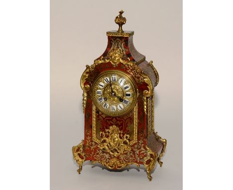 A French Louis XVI style boulle work mantel clock, having a red tortoiseshell case with brass foliate inlaid panels decorated