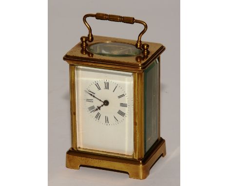 A brass carriage clock, with handle above enamel dial with Roman numerals, 16cm high