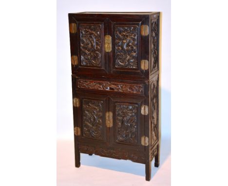 A 19th century Chinese Hongmu two section cabinet, with carved panelled doors to top and bottom, dragon decoration and carved