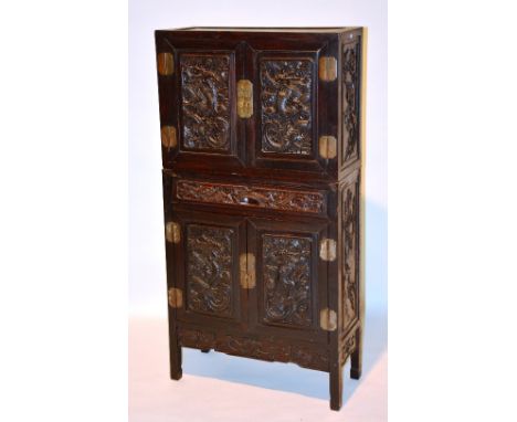 A 19th century Chinese Hongmu two section cabinet, with carved panelled doors to top and bottom, dragon decoration and carved