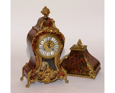 A French Louis XVI style boulle work mantel clock, with original wall bracket, having a red tortoiseshell case with brass fol