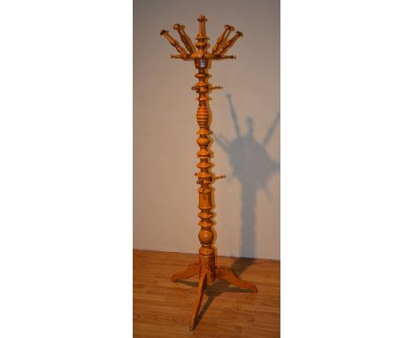 A vintage orange painted hat and coat stand, with outstretched pegs, ring turned column, raised on tripod supports, 193cm hig