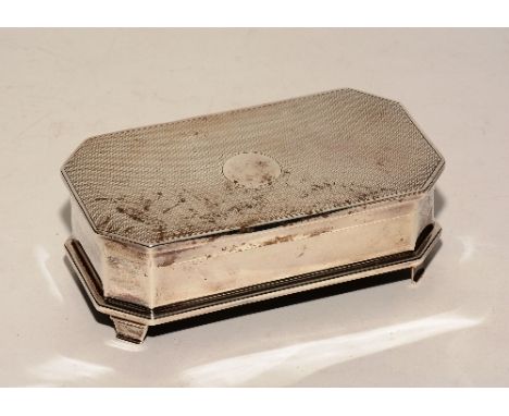 A silver jewellery box, of rectangular form with canted corners, the engine turned hinged lid with plain circular cartouche t