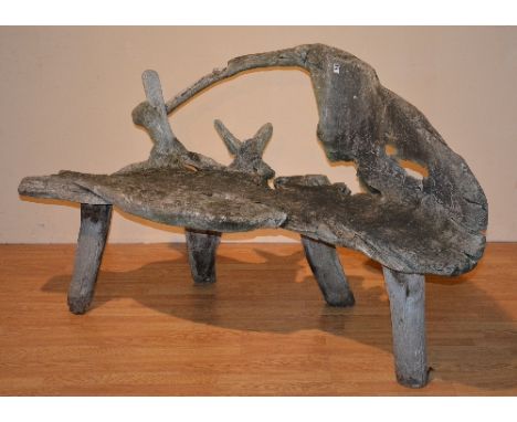 A naturalistic tree trunk garden seat, 95cm high x 164cm wide