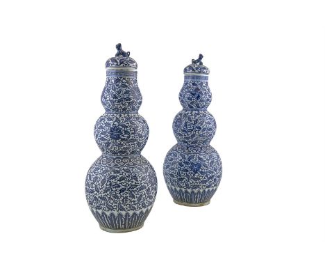 A PAIR OF CHINESE BLUE AND WHITE TRIPLE GOURD SHAPED VASES AND COVERS, 19th century, each detachable cover surmounted with a 