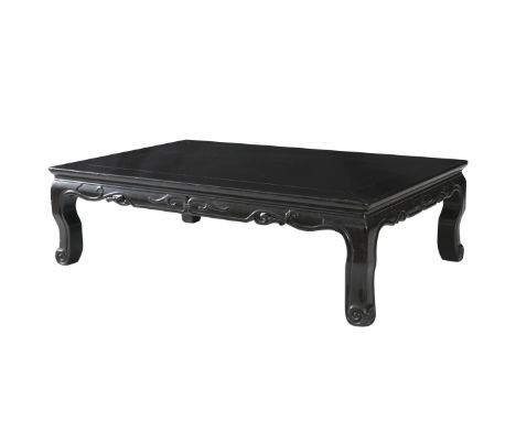 A CHINESE EBONISED LOW TABLE, of rectangular form with plain moulded top and short frieze carved with archaic design on scrol